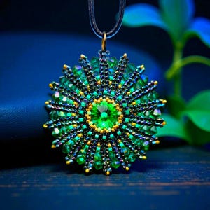 Può includere: Una collana con pendente artigianale con un motivo floreale di perline. Il pendente presenta una gemma verde centrale, circondata da perline verdi e dorate, creando un effetto a stella. La collana è sospesa a un cordino scuro. Diametro: circa 5 cm.