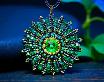 May include: A circular pendant featuring a large, faceted lime green crystal at the center, surrounded by concentric layers of smaller dark green and iridescent beads. The intricate beadwork radiates outward in a sunburst pattern on a dark cord.