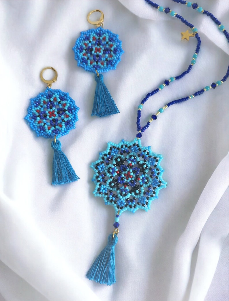 May include: A blue and black beaded necklace with a star charm and a matching pair of earrings. The necklace and earrings feature a mandala design with a blue tassel.