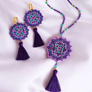 May include: A purple and turquoise beaded necklace with a mandala pendant and matching earrings. The necklace and earrings have purple tassels.