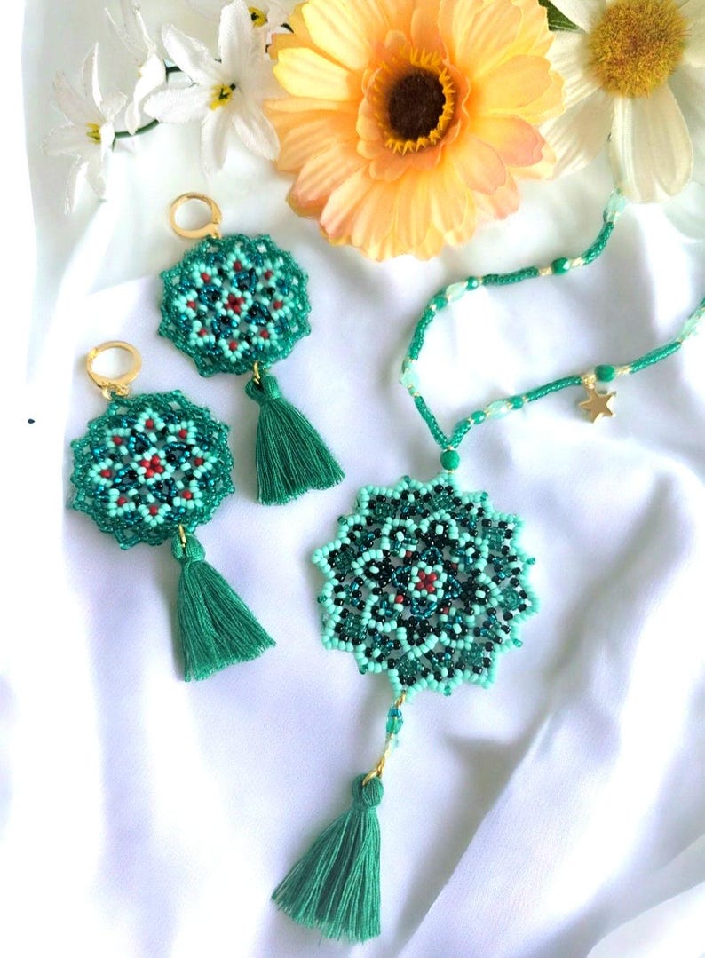 May include: A set of green beaded jewellery with a star charm, featuring a mandala design and tassel accents.