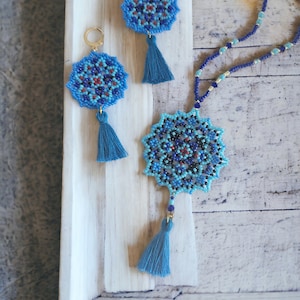 May include: A set of blue and black beaded earrings and a necklace with tassel accents. The jewellery features a mandala design.