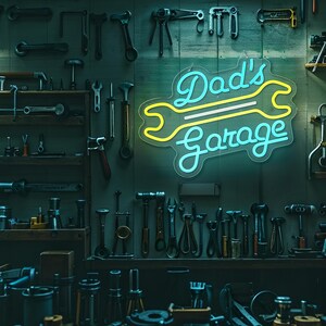 May include: A workshop scene with a neon sign that reads "Dad's Garage" in blue and yellow. Various tools are displayed on the wall and shelves, including wrenches, hammers, and other hardware. The lighting creates a moody, industrial atmosphere.