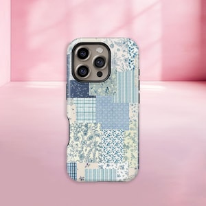 May include: A phone case with a patchwork design in shades of blue and white. The case features a variety of patterns, including floral prints, stripes, and plaid. The case is designed to fit a smartphone with a triple-lens camera.