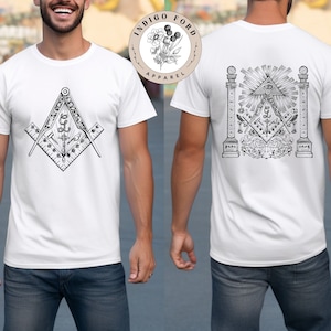 Puede incluir: Camiseta blanca con un gráfico en blanco y negro de una brújula y otros símbolos masónicos en la parte delantera. La parte posterior de la camiseta presenta un diseño más elaborado con una brújula, una escuadra y un ojo que todo lo ve.