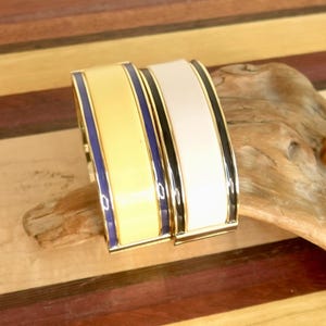 2 Hinged Chunky Talbot Stackable Clamper Bracelets: First - Yellow with 2 Navy Blue Lines; Second - White with 2 Black Lines.