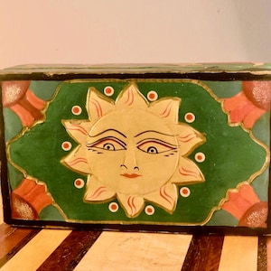 Sole indonesiano, luna e stelle con fiori rossi su sfondo verde su una scatola decorativa per gioielli, bigiotteria e dadi. Vintage anni '90.