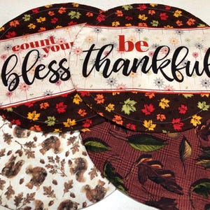 May include: A set of three ceramic mugs with a speckled, matte finish. The mugs are in shades of cream, light brown, and dark brown. Each mug has a simple, minimalist design, perfect for coffee or tea.