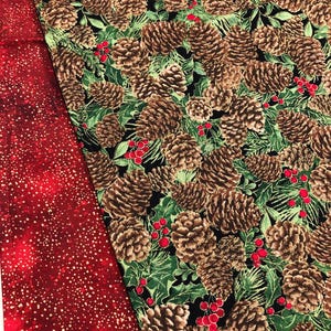 May include: A close-up of a fabric with a repeating pattern of pine cones and holly berries on a black background. The fabric is green, brown, and red.