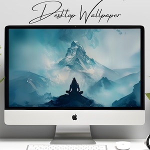 Op de afbeelding: Een desktopcomputer toont een serene berglandschap met een mediterende figuur. Het scherm heeft een blauw-wit kleurenpalet, met de woorden "Desktop Wallpaper" in cursief bovenaan. De computer staat op een witte tafel.