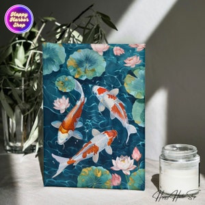 May include: A blue canvas print with three orange and white koi fish swimming in a pond with pink lotus flowers. The background is a dark blue with white water ripples.