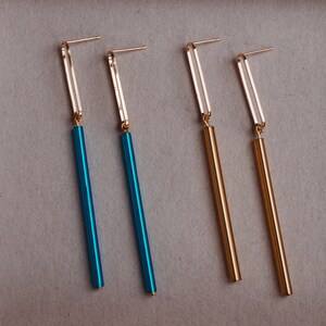 Peut inclure: Quatre longues boucles d'oreilles fines avec des crochets dor&eacute;s et des tiges pendantes. Deux tiges sont dor&eacute;es et deux sont bleues.