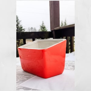 May include: A white ceramic mug with a black handle and the text "But First, Coffee" in a bold, black font. The mug is set against a blurred background, suggesting a cozy setting. The mug appears to be approximately 4 inches tall.