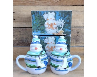 1995 Boston warehouse skater snowman mugs with tops. (2)  Ice skater snowman mugs.  Snowman shaped mugs.  Ceramic snowman mug set.
