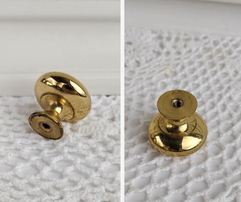 Op de afbeelding: Twee aanzichten van een goudkleurige kastknop. De knop heeft een afgeronde bovenkant en een korte, cilindrische basis. Het metaal heeft een glanzende afwerking. De knop is ontworpen voor meubels en woondecoratie.