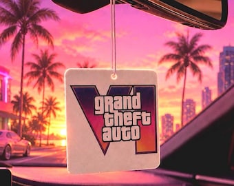 Może przedstawiać: Kwadratowy odświeżacz powietrza do samochodu zawieszony na lusterku wstecznym, z logo Grand Theft Auto VI w gradiencie fioletu, różu i pomarańczu. Projekt zawiera pogrubiony napis Grand Theft Auto VI na tle zachodzącego słońca.