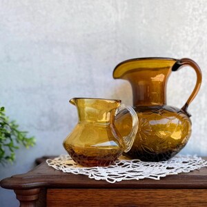 Vintage Amber Glass Pitcher Pair – 1970s Retro Fall Decor – Clear Handle & Floral Embossed – Display Only and Serving Pitcher Set