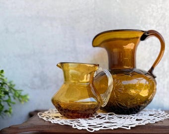 Vintage Amber Glass Pitcher Pair: Floral Embossed, Clear Handle - 1970s Retro Decor