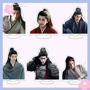 May include: A set of six acrylic standees featuring a person with long dark hair styled in various traditional updos and ponytails. The figures are dressed in diverse historical-style robes, including red, blue, grey, and white garments.
