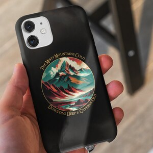 Könnte beinhalten: Schwarze Handyhülle mit einer kreisförmigen Grafik einer Bergkette mit dem Text "The Misty Mountains Cold Dungeons Deep & Caverns Old".