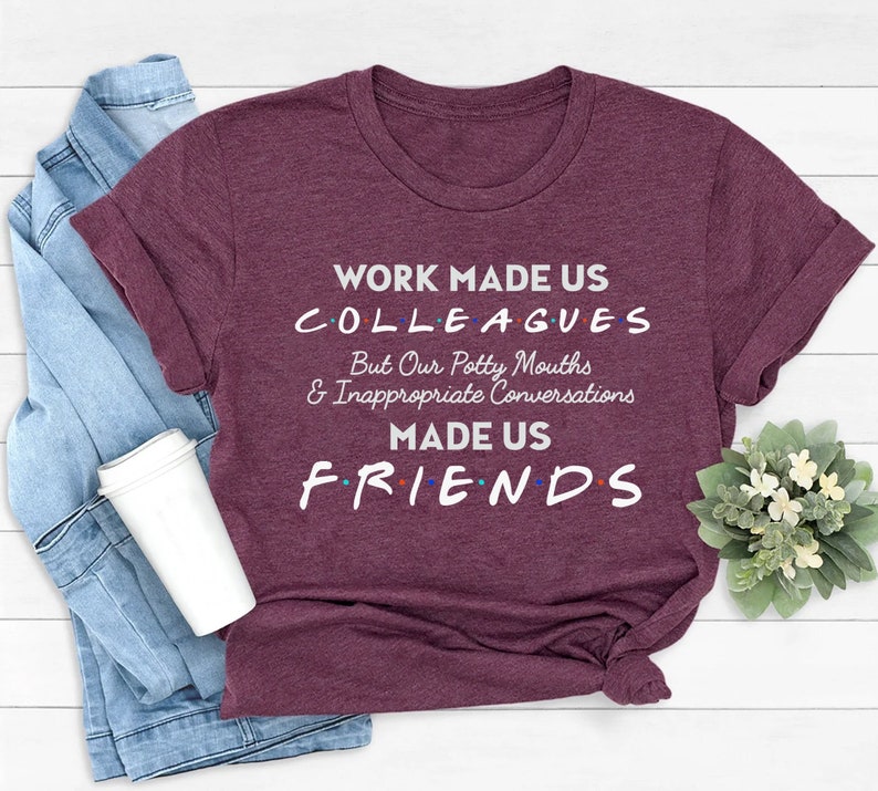 May include: Burgundy t-shirt with the text "Work made us colleagues but our potty mouths & inappropriate conversations made us friends".