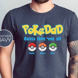 May include: Heather navy blue t-shirt with the text "PokeDad Gotta love 'em all" and three Pokeballs with the names Emily, Adam, and John underneath.