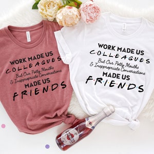 May include: Two t-shirts with the text "Work made us colleagues but our potty mouths and inappropriate conversations made us friends". The shirts are in pink and white.