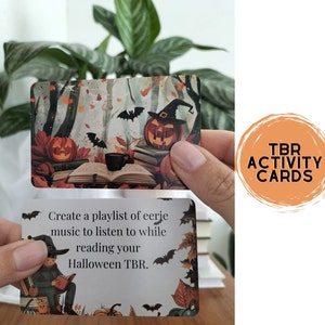 A set of small cards, each beautifully designed with Halloween-themed imagery, and titled: Halloween Whispers- A TBR and Activity Spellbook. In the colors orange, black and brown. The cards offer 27 reading prompts and 6 activities.