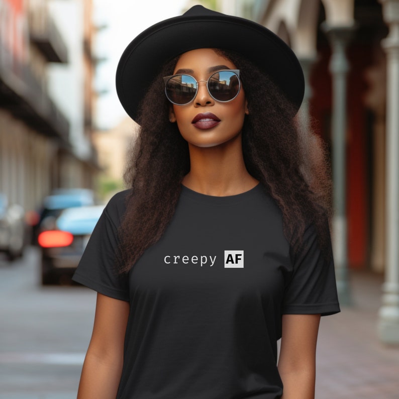 May include: A black t-shirt with the text "creepy AF" in white lettering.
