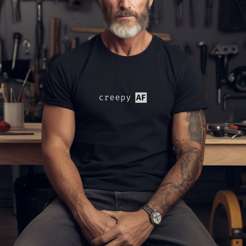 May include: A black t-shirt with the text "creepy AF" printed in white on the front.