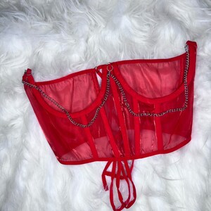 Op de afbeelding: Rood mesh corset top met zilveren kettingdetails en een veter aan de achterkant.