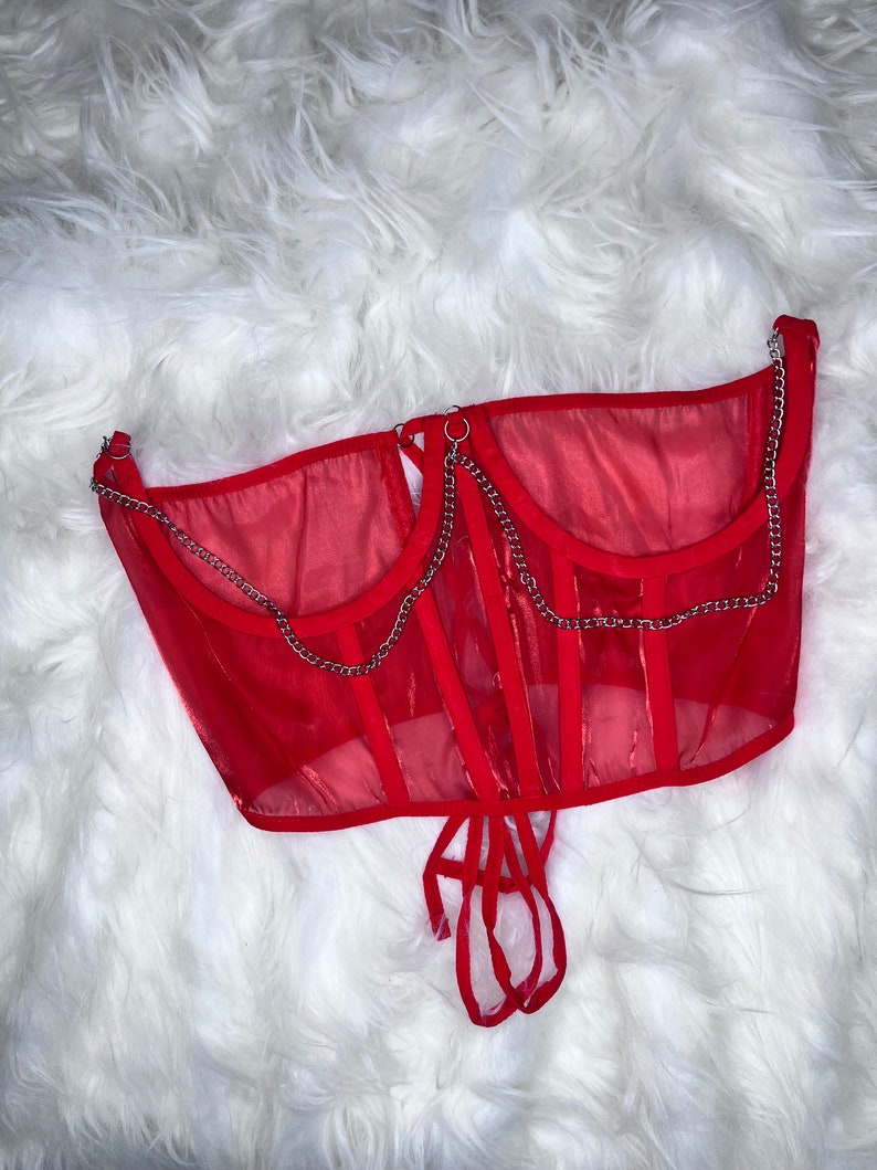 Op de afbeelding: Rood mesh corset top met zilveren kettingdetails en een veter aan de achterkant.