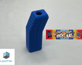 May include: A blue plastic joystick handle with a textured grip and a round hole at the top. The handle is angled and has a rectangular shape. The handle is for a vintage arcade game.