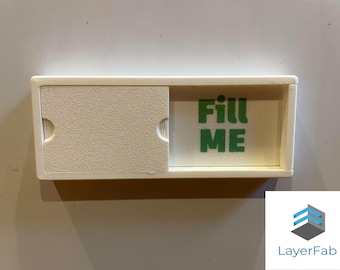 May include: A white plastic box with a sliding lid. The box has a green label that says "Fill Me".