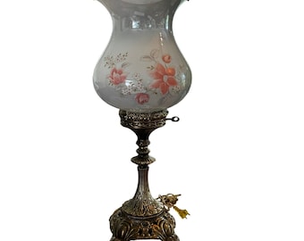 Lámpara de mesa tipo huracán floral vintage con pantalla de cristal blanco opalino.