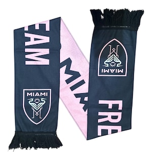May include: A black and pink scarf with the text "MIAMI" and "FRE TEAM" in pink. The scarf has a team logo on each end and black fringe.