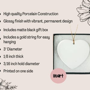May include: A white heart-shaped porcelain ornament with a glossy finish, presented in a matte black gift box. The ornament has a 3-inch diameter and includes a gold string for hanging. The text "Heart" is on a pink circle.