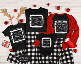 May include: Black t-shirts with a white framed graphic that reads "Christmas at the Beach 2025" are displayed with matching black and white plaid pajama pants. A red cardigan and baby onesie are also shown. The text "LISTING IS FOR JUST SHIRTS" is at the bottom.