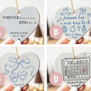 May include: Heart-shaped ceramic ornaments with gold string for hanging. Each ornament features a different design and text in black or blue, including phrases like "Forever has a nice ring to it" and names with dates. Ideal for engagement or wedding gifts.