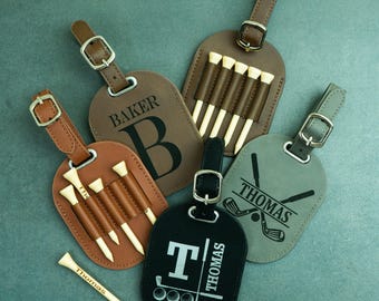 May include: Four personalised leather luggage tags with golf tee holders. The tags are brown, grey, and black with white and grey text. The tags feature the names "Baker", "Thomas", and a golf club design.