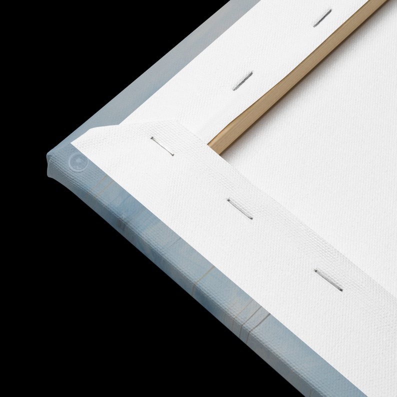 May include: Close-up of the edge of a stretched canvas painting. The canvas is white and is wrapped around a wooden frame. The canvas is secured to the frame with staples.