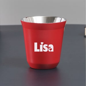 Puede incluir: Un vaso rojo con interior plateado. La palabra "Lisa" está impresa en blanco, con un símbolo de corazón. El vaso probablemente está hecho de metal o un material similar.