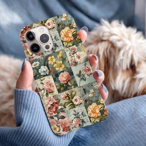 May include: A floral patterned phone case featuring a patchwork design of roses and other flowers in shades of pink, yellow, and white. The case has a light blue background and a camera cutout.