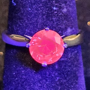 Pierścionek z rubinem szlifem okrągłym Solitaire, rozmiar 7, wykonany z nowego srebra próby 925 z rubinem o średnicy 8 mm, który świeci w świetle czarnym/UV