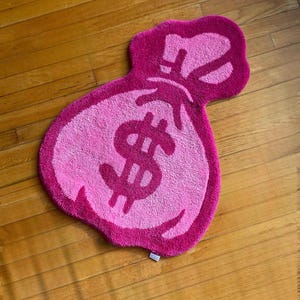 Tappeto rosa con sacco di soldi
