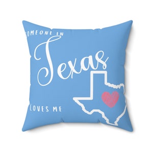 Puede incluir: Una almohada azul claro con el texto "Alguien en Texas me quiere" y un contorno del estado de Texas con un corazón rosa en el centro.