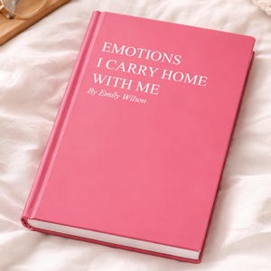 Hardcover notebook reading “Emotions I Carry Home With Me” on a soft bed beside a coffee mug, glasses, and cozy blanket