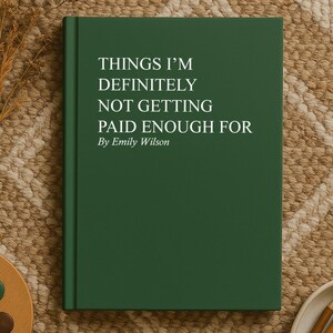 May include: A dark green book titled "THINGS I'M DEFINITELY NOT GETTING PAID ENOUGH FOR" by Emily Wilson. The book is on a woven rug with a palette, paint brush, pencils, and dried flowers.