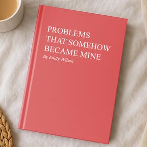 May include: A coral-colored book titled "PROBLEMS THAT SOMEHOW BECAME MINE" by Emily Wilson. A white mug filled with coffee sits to the left of the book. The book and mug are on a white surface.