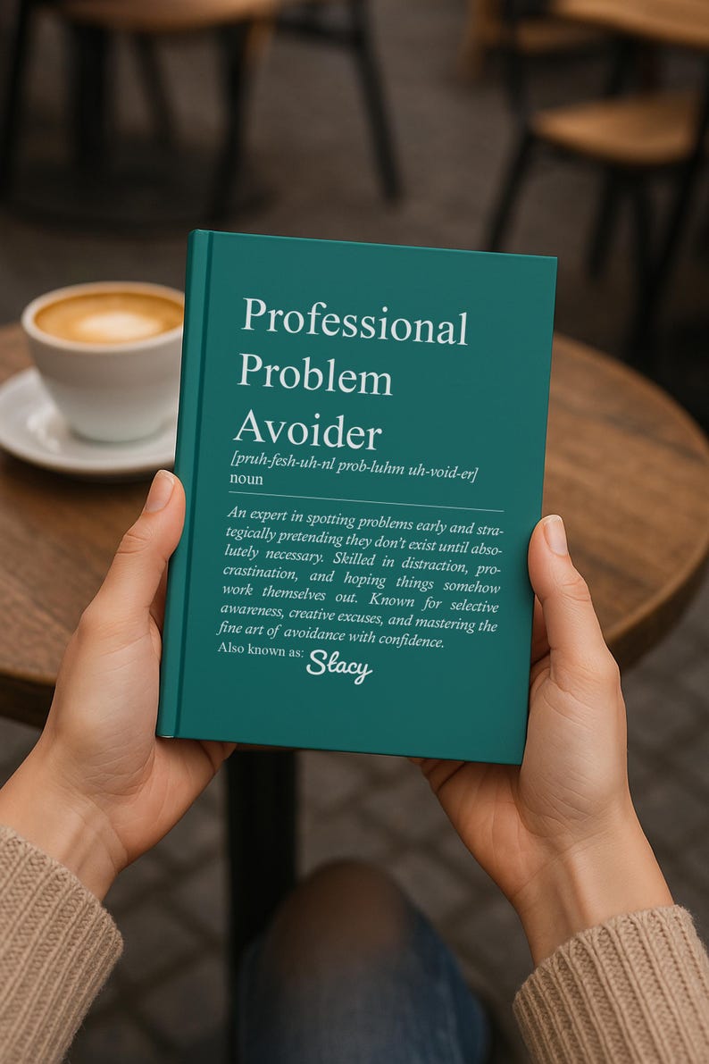 May include: A teal book titled "Professional Problem Avoider" is held by hands. The book's definition is printed in white, with the name "Stacy" at the bottom. A cup of coffee sits on a wooden table in the background.